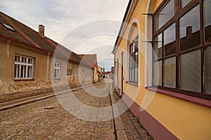 Narrow and long cobblestone street. One of the old typical street in residential part of Telc. Southern Moravia, Czech Republic