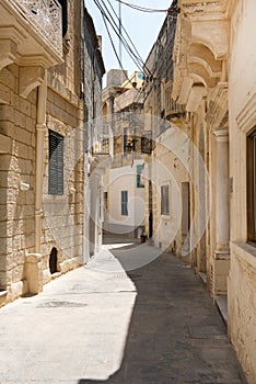 Narrow medieval street with stone houses in Mdina, Malta