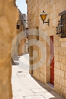 Narrow medieval street with stone houses in Mdina, Malta