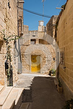 Narrow medieval street with stone houses in Mdina, Malta