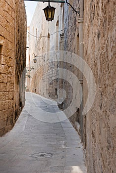 Narrow medieval street with stone houses in Mdina, Malta