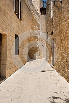 Narrow medieval street with stone houses in Mdina, Malta