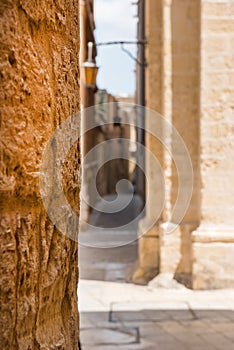 Narrow medieval street with stone houses in Mdina, Malta