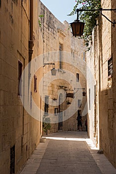 Narrow medieval street with stone houses in Mdina, Malta