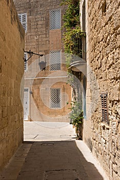 Narrow medieval street with stone houses in Mdina, Malta