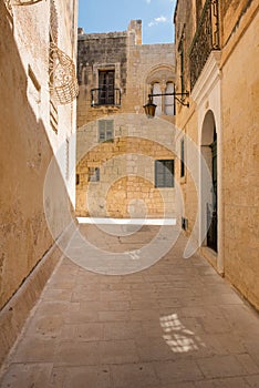 Narrow medieval street with stone houses in Mdina, Malta