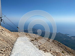 Narrow mountain road winding high above the sea