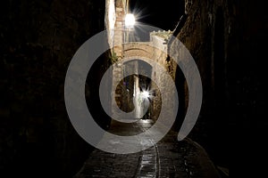 Narrow passage at night in San Gimignano, Italy