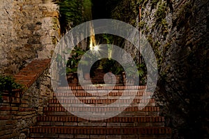 Narrow passage and stairs at night in San Gimignano, Italy