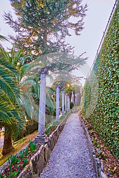 The narrow path along the ancient columns in park Villa Heleneum in Lugano, Switzerland