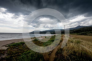 A narrow path on the beach in the dark weather. photo