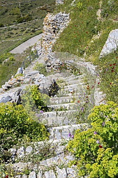 Narrow path with stone stairs in the mountains Cyclades, Andros Island, Greece