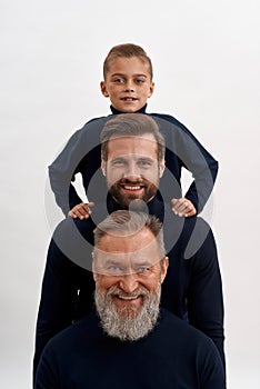 Narrow portrait of three generations of men posing