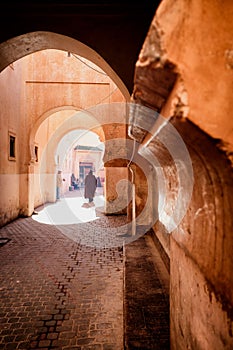 Narrow red alley street in medina of Marrakech, Morocco. photo