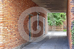 Narrow red brick wall alley in old town.