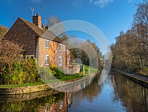 Narrow river surrounded by trees and houses under the sunlight in Ironbridge, England