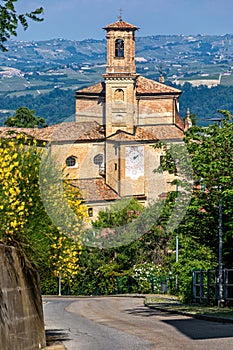 Narrow road and old brick church in Guarene, Italy.