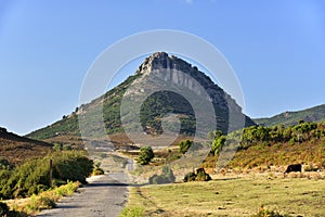 The narrow road with Panoramic Mountain Landscape with layered by blue sky over the mountain ranges, Sardinia, Orosei region