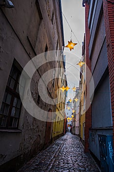 Narrow Rozena street in old town Riga, Latvia with stars garland. Christmas decoration on the european street. Rozena iela