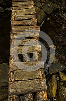 Narrow and ruined small wooden bridge at Black river gorge