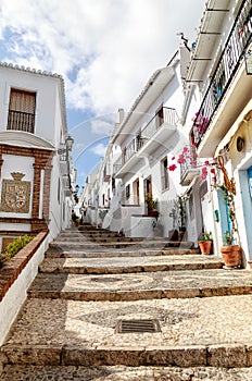 A narrow steep pattern paved alley in Frigiliana, one of Andalucia`s famous `White Villages` on the Costa del Sol in Southern Spai