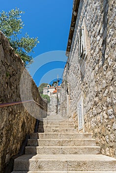 narrow stone stairs between old residential area in croatia. Adriatic coast village with stone houses and Old stone street of