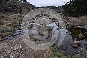 Narrow stream of Charon's Garden trail in Wichita Mountains with greenery trees in Oklahoma photo
