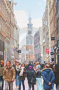 Narrow street of Amsterdam crowded with tourists