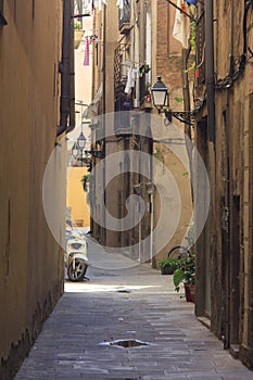 Narrow street with antique lantern and scooter photo