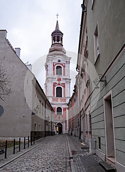 Narrow street and bell tower of Church or Basilica of Our Lady of Perpetual Help, Mary Magdalene and Saint Stanislaus, Pol