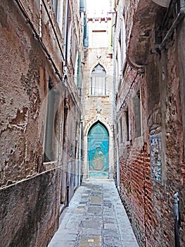 Narrow street and blue door in the city of Venice, Italy