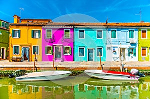 Narrow street with blue, red, green and purple house facade in the island of Burano, Venice