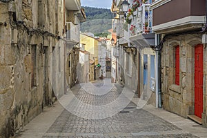 An narrow street and the buildings in the center of Fisterra, the final destination of the Camino de Fisterra. Galicia, Spain.