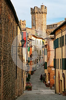 Narrow street in historic center of Montalcino town with fortre