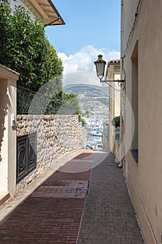 Narrow street leading to the harbor of the peninsula of Saint-Jean-Cap-Ferrat on the Cote d `Azur in France