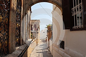 Narrow street in Lindos town on Rhodes island, Dodecanese, Greece. Beautiful scenic old ancient white houses