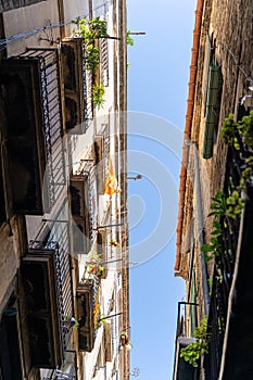 Narrow street with old historic houses with windows, balconies in Barcelona
