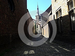 Narrow street of old medieval european city, Bruges, Belgium.