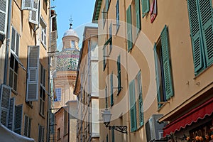 Narrow street in the old town in Nice France with a view of Saint Reparate Cathedral dome