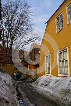 Narrow street in the old town of Tallinn covered by, snowbanks. Estonia