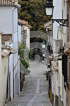 Narrow street of stone paviment with lamps photo