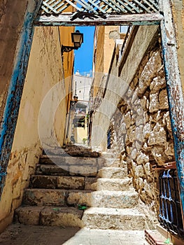 Narrow street and stone steps in the center of Alicante, Spain. Old city with ancient buildings, touristic destination