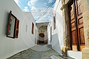 Narrow street with traditional white houses in Lindos