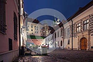 Narrow street with view of Wawel castle at night in Krakow, Poland