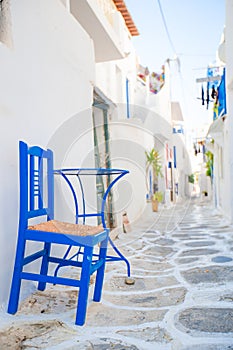The narrow streets with blue balconies, stairs, white houses and flowers in beautiful village in Greece.