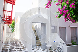 The narrow streets with blue balconies, stairs, white houses and flowers in beautiful village in Greece. Beautiful