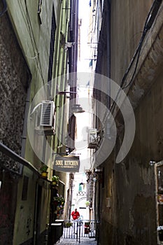 The narrow streets of the city of Genoa Italy. Old cobblestone road in the window grilles. Beautiful Perspective Lane. A good