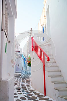 The narrow streets of greek island with balconies, stairs and flowers. Beautiful architecture building exterior with