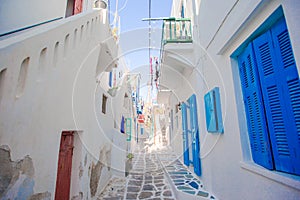 The narrow streets of greek island with blue balconies, stairs and flowers. Beautiful architecture building exterior