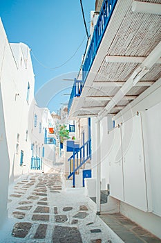 The narrow streets of the island with blue balconies, stairs and flowers.